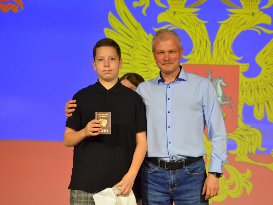 Заместитель главы Краснознаменска Владимир Парамонов вручает первый паспорт РФ. Фото: Администрация Краснознаменска