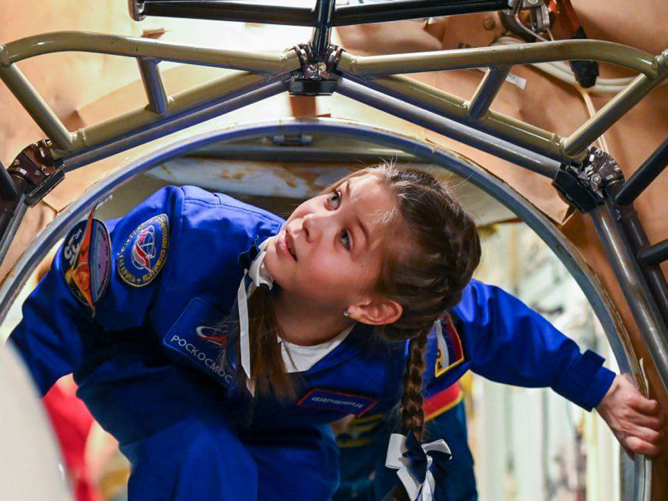 Девочка оценила макет пилотируемого транспортного корабля. Фото: пресс-служба Центра подготовки космонавтов имени Ю. А. Гагарина / Павел Швец