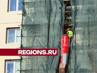 Кирпичи с фасада многоквартирного дома в Чехове строители ловят буквально на лету