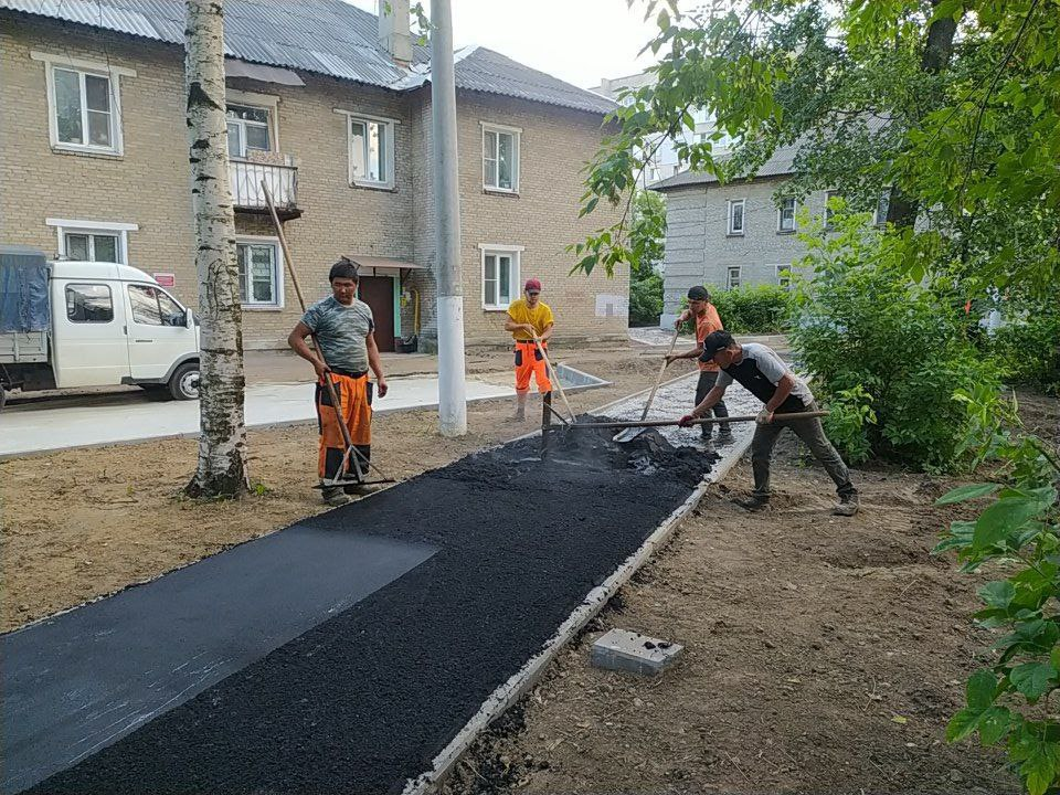 Во дворе на улице Расковой рабочие укладывают асфальт