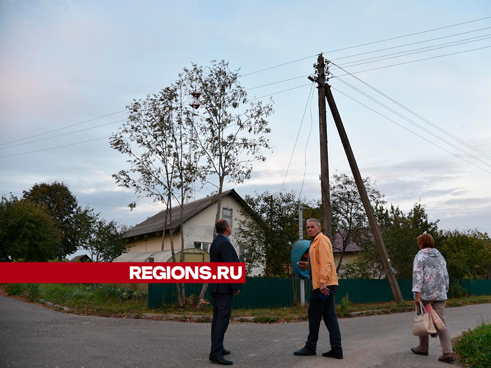 Рабочие починят фонарь рядом с почтой в деревне Коноплево