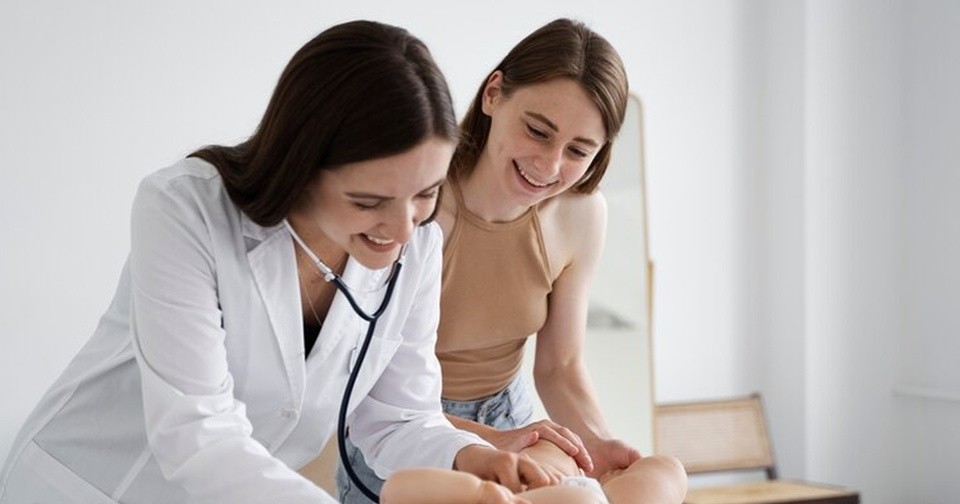 врач осматривает новорожденного