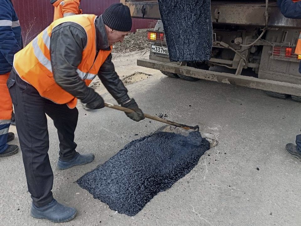 Рабочие заделают ямы на городских дорогах