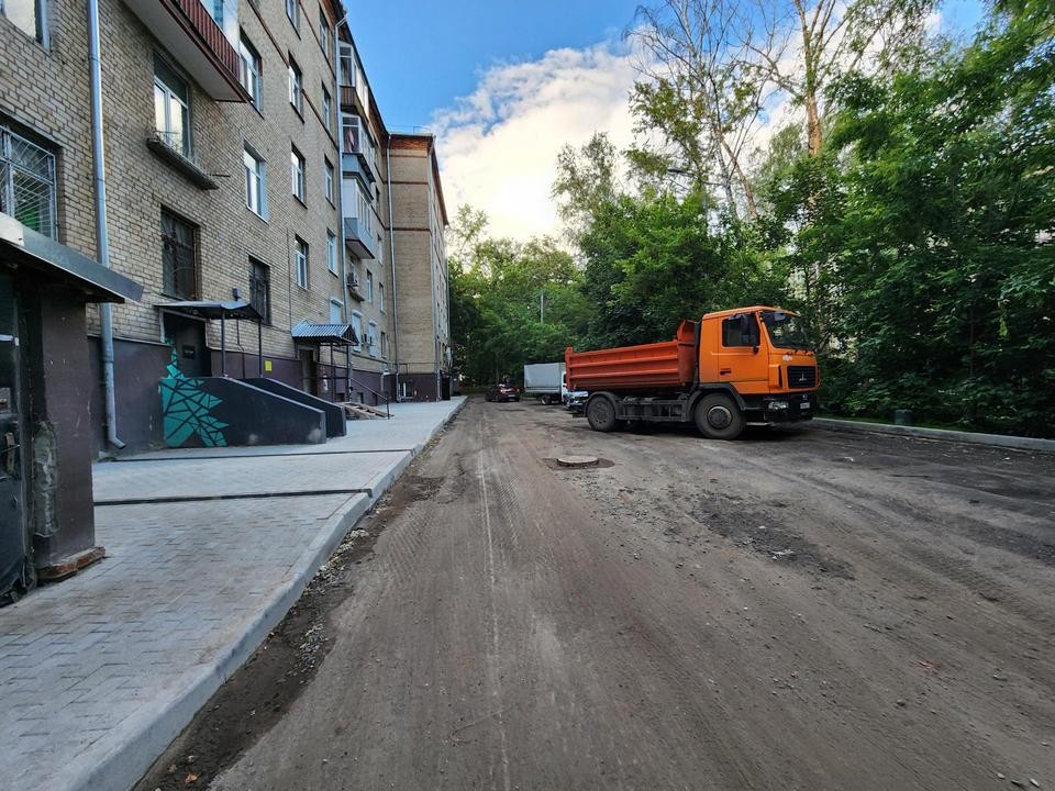 Рабочие меняют асфальт и тротуары во дворах в районе улицы Щербакова в Мытищах