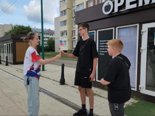 Волонтеры в День России вручили жителям сотни флажков с триколором