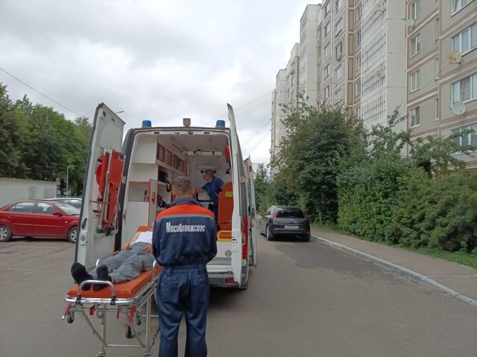 Спасатели перенесли тяжелобольного пенсионера в машину скорой помощи в Кашире