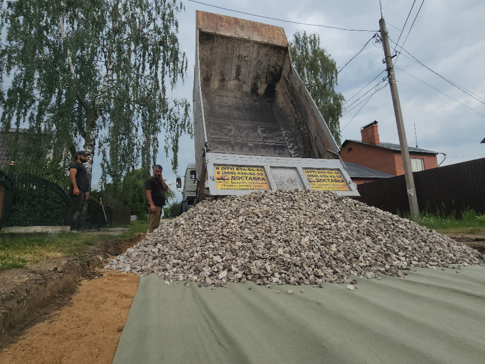 На улице Крылова дорожники укладывают щебень и устанавливают бортовой камень