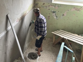 На улице Комсомольская штукатурят подъезды в жилом доме