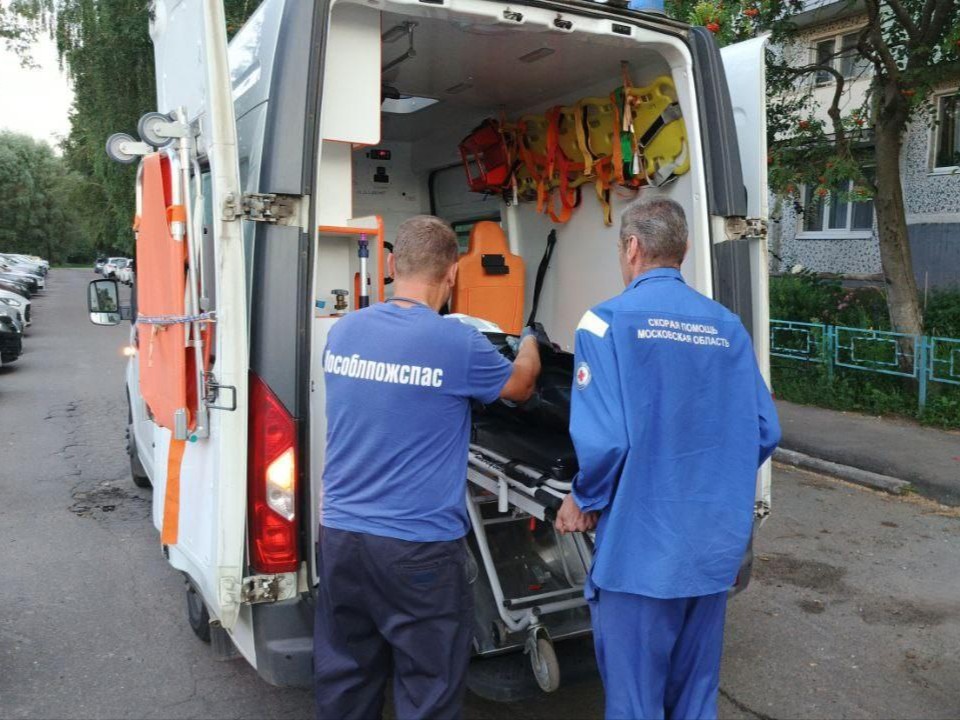 Спасатели транспортировали больную пенсионерку в машину скорой помощи в Коломне