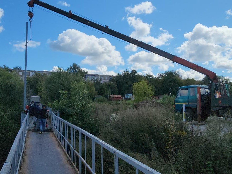 Столбы освещения появились на пешеходном мосту к улице 1-ой Дзержинской