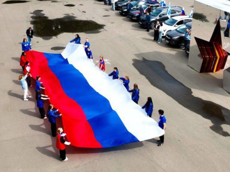 Перед началом автопробега ко Дню Государственного флага в Подмосковье развернули триколор