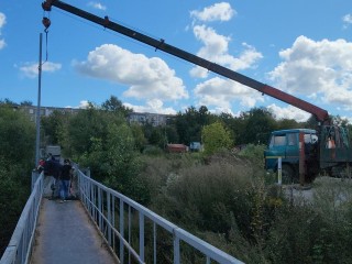 Столбы освещения появились на пешеходном мосту к улице 1-ой Дзержинской