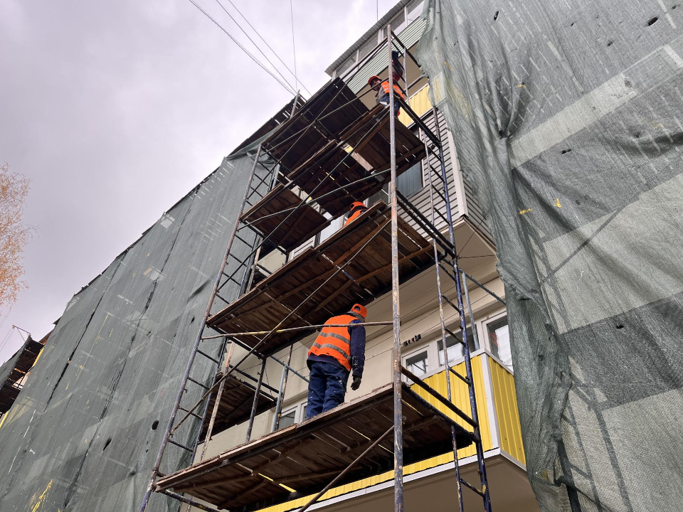 Рабочие заделывают швы и окрашивают фасад дома №28 по улице Энергетиков