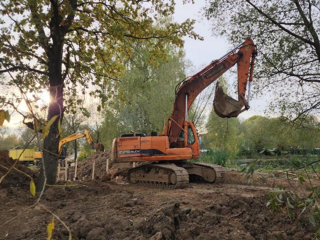 Рабочие раскапывают траншеи вдоль озера Киово для прокладки коммунальной сети