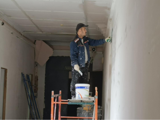 В здании школы мозаики строители укладывают новые полы и штукатурят стены