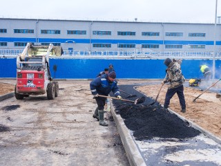 На территории новых очистных укладывают асфальт и красят ограждения