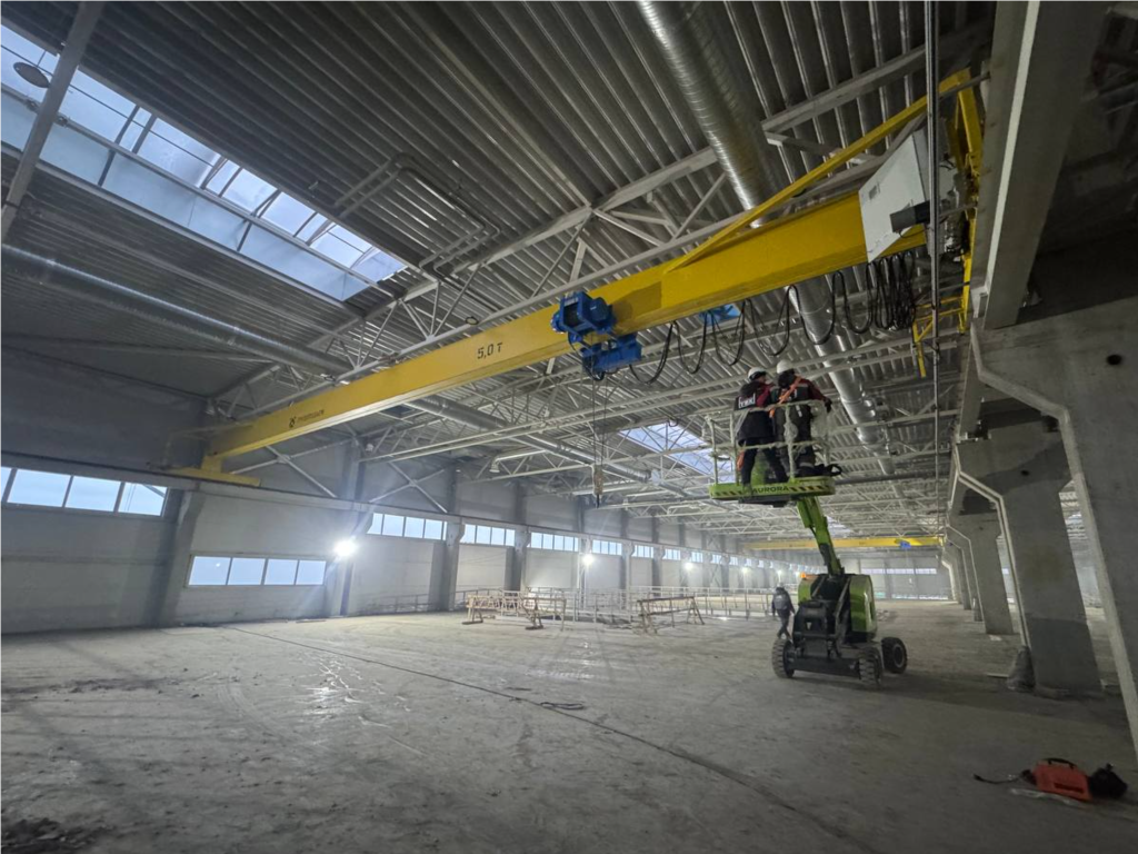 В строящемся здании завода по производству домокомплектов монтируют кран-балки