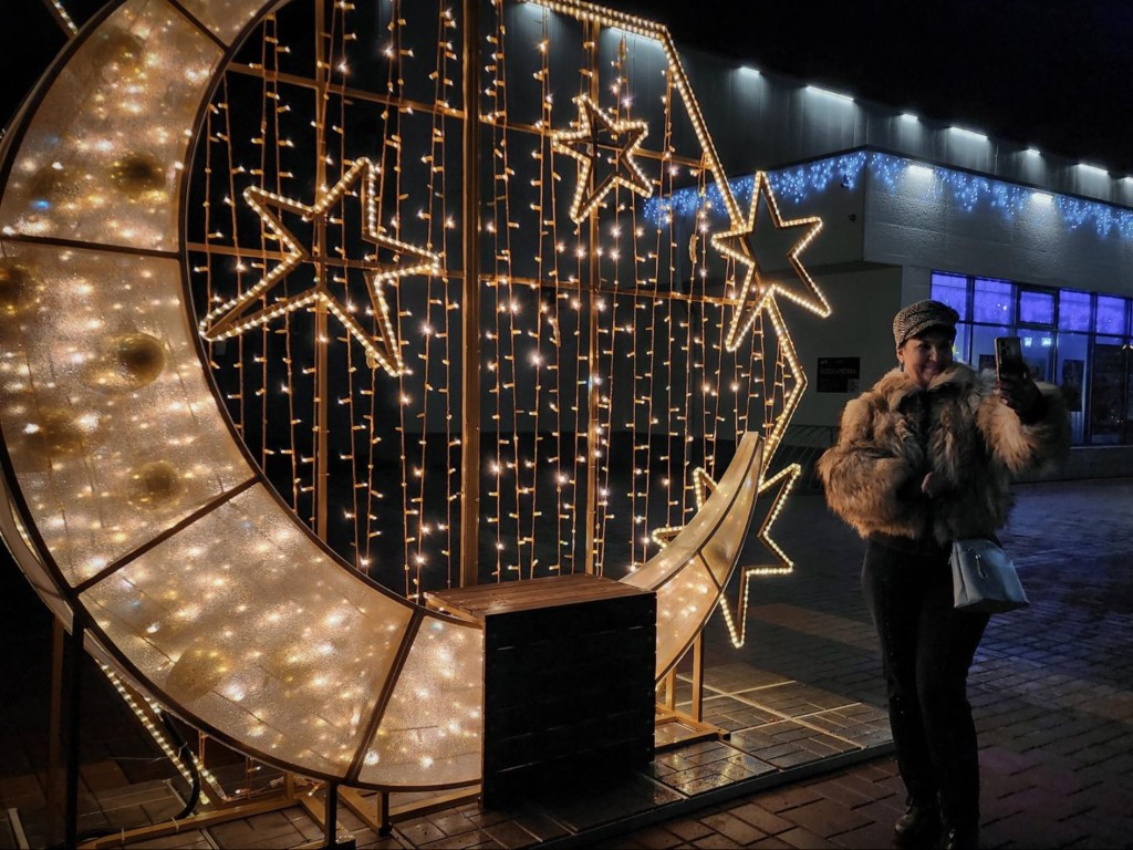 Где все делают селфи? Родители с детьми делают новогоднее фото у светящегося месяца