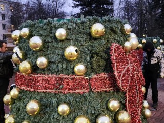 Новогоднюю елку украшают шарами и светящейся гирляндой на Московской улице