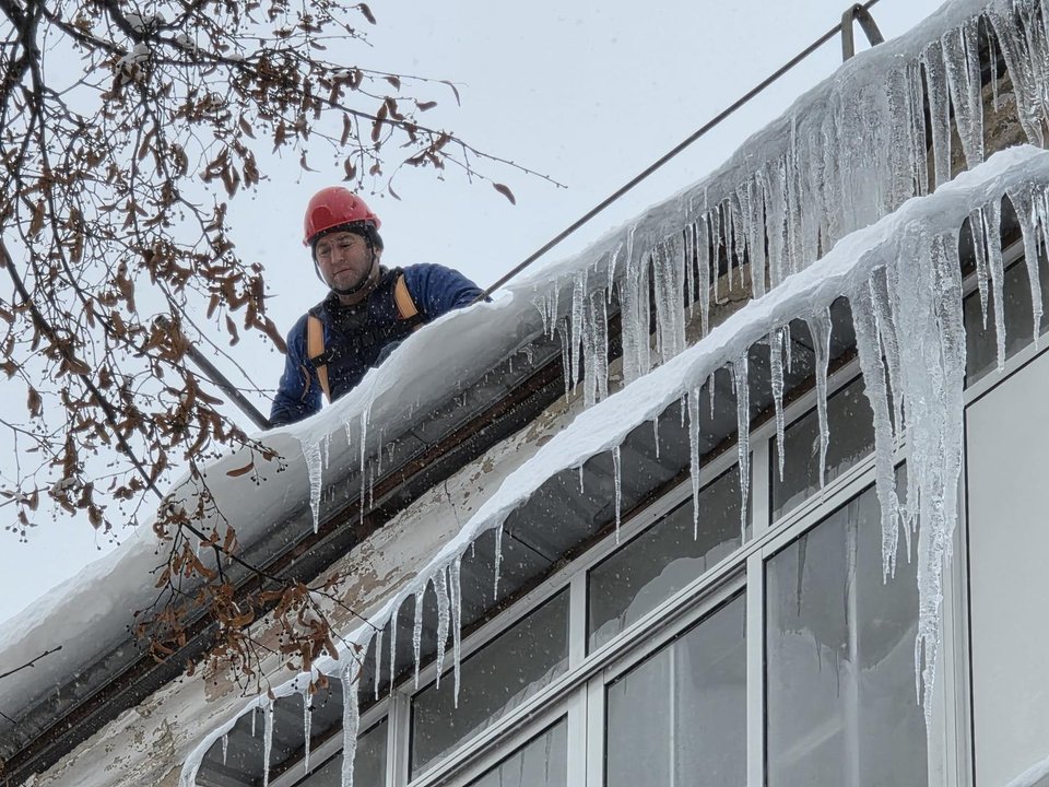 «Верхние» и «нижние»: как в Дзержинском очищают крыши домов от снега и льда