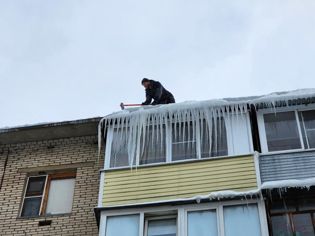 В Протвине расчищают крыши от снега и сосулек: работы идут во дворе на улице Гагарина