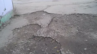 Во двор не проехать - дорога на улице Новаторов усеяна глубокими ямами