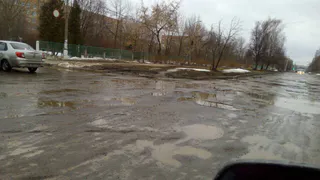 "Дорога сошла вместе со снегом": разбитый асфальт около детской поликлиники сняли на видео