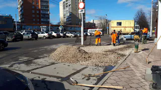 На месте, где вчера провалился под землю припаркованный автомобиль, яму снова засыпали щебнем