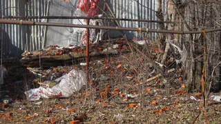 Рабочие скидывают мусор с крыши дома на частный сектор