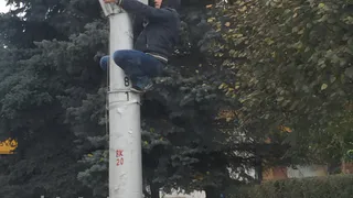 В центре Рязани прохожий залез на столб и что-то искал на нем
