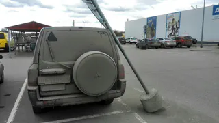 На парковке ТРЦ "Премьер" дорожный знак упал на машину