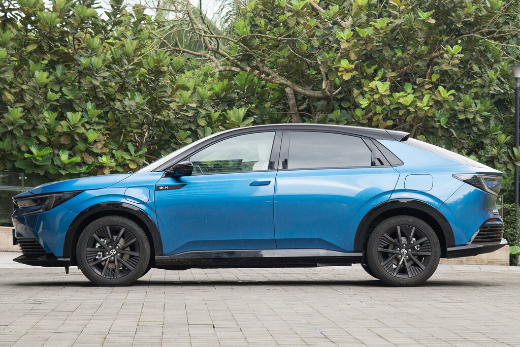 Honda e:NP2 сбоку — фирменный профиль с покатой крышей и скрытой ручкой задней двери, значок e:N на крыле