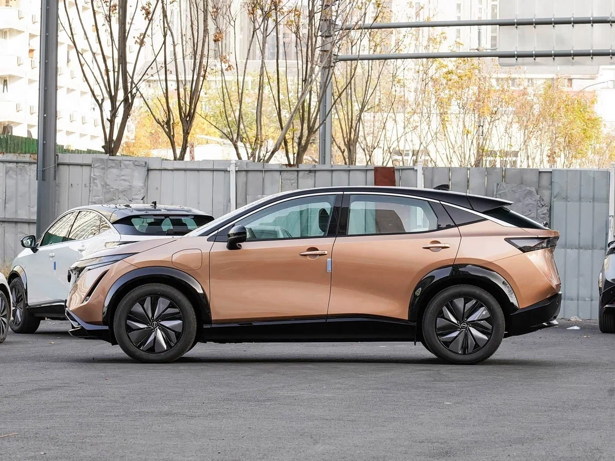 Nissan Ariya 2026 — вид сбоку, виден лючок зарядки на переднем крыле; кузов «кроссовер» с покатой крышей