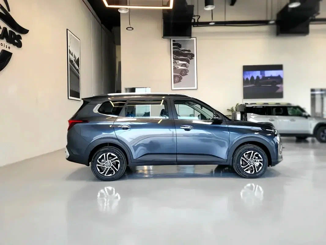 Kia Carens сбоку — кузов минивэна с покатой крышей, семь мест в три ряда