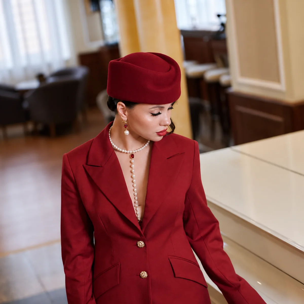 Основательница BONETTA в бордовом костюме и шляпе у рояля