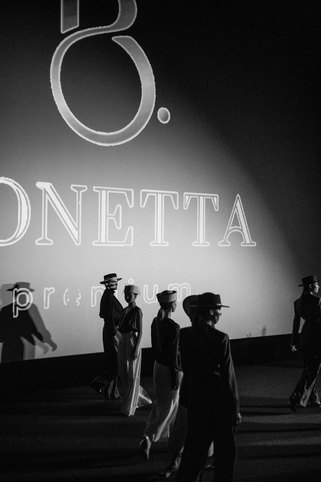 Модели в шляпах на подиуме перед экраном с логотипом BONETTA