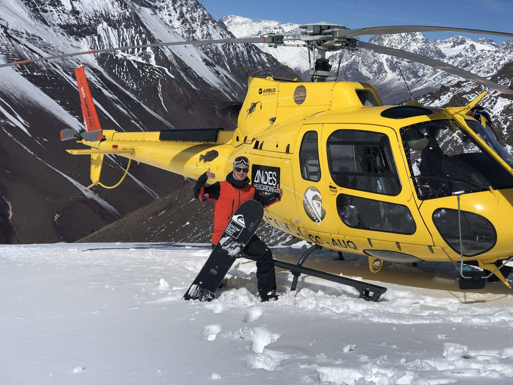 Райдер у жёлтого вертолёта Airbus AS350 в Андах, Чили