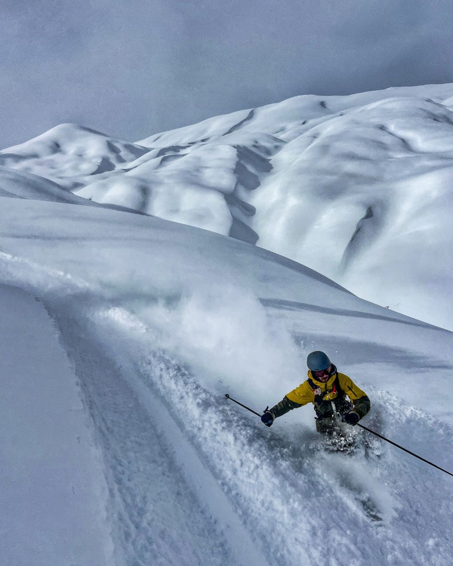 Skier in a yellow jacket on a powder run