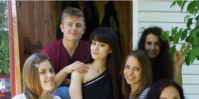 Алина (27 лет) и Митчелл (25 лет). Алина сидит по центру в чёрном платье. Митчелл держит её за плечо.