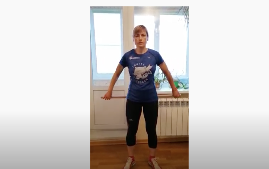 Это упражнение от инструктора “Московского долголетия” Татьяны Шейгас можно выполнять со шваброй. Фото скриншот видео YouTube-канал Татьяны Шейгас