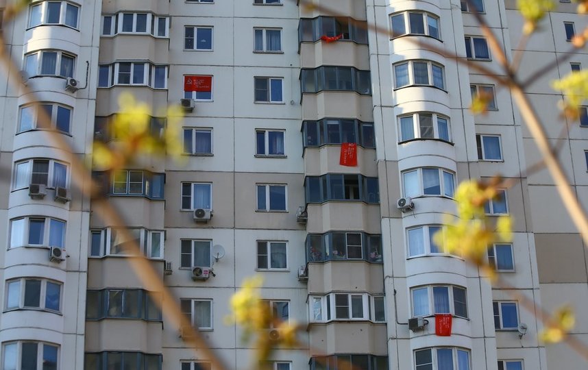 Жители некоторых домов вывесили на окнах и на балконах Знамя Победы. Фото АГН "Москва"/Сергей Ведяшкин
