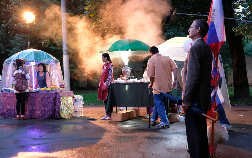 На городской площади – праздник, среди веселящиъся людей выделяется напуганная Мухаббат, девушка в фартуке, сбежавшая из магазина. Новый день съёмок фильма "Продукты 24". Фото пресс-служба Metrafilms