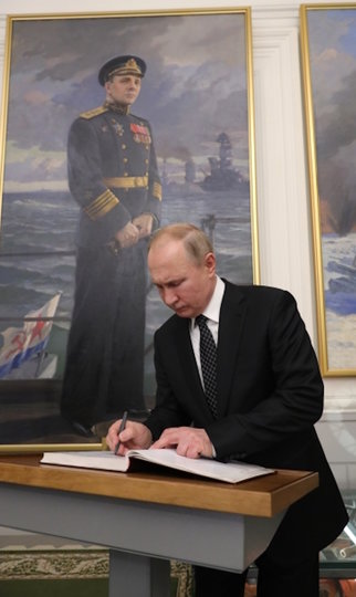 резидент РФ Владимир Путин оставляет запись в книге почетных посетителей во время посещения Государственного мемориального музея обороны и блокады Ленинграда в Санкт-Петербурге. Фото РИА Новости
