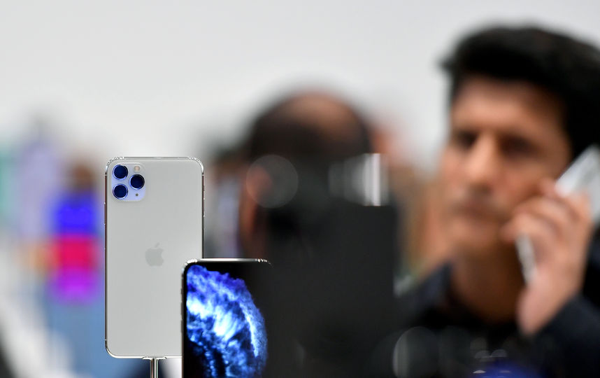 Люди с выставочными смартфонами на презентации. Фото AFP