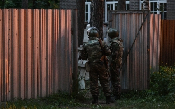 Сотрудники Росгвардии стоят в оцеплении на одной из улиц поселка Кратово, где мужчина забаррикадировался в своем доме и стал стрелять по людям из окна. Фото Максим Блинов, РИА Новости