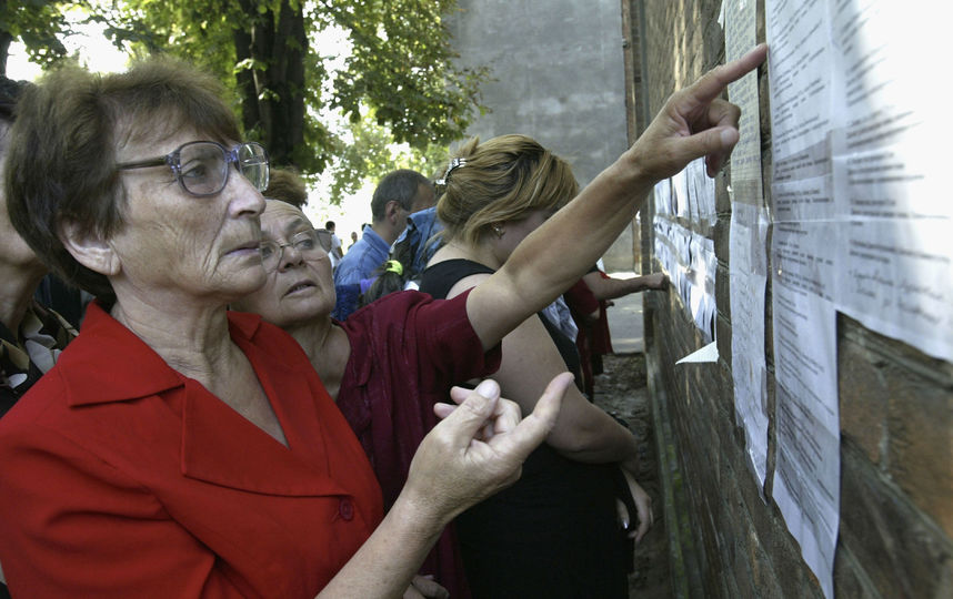 Женщина читает списки погибших, 2004-й год. Фото Getty