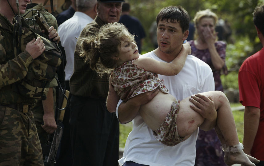 Мужчина выносит потсрадавших из зданий школы. 2004-й год. Фото Getty