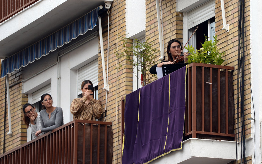 Играют на скрипке для соседей. Севилья, Испания. Фото AFP