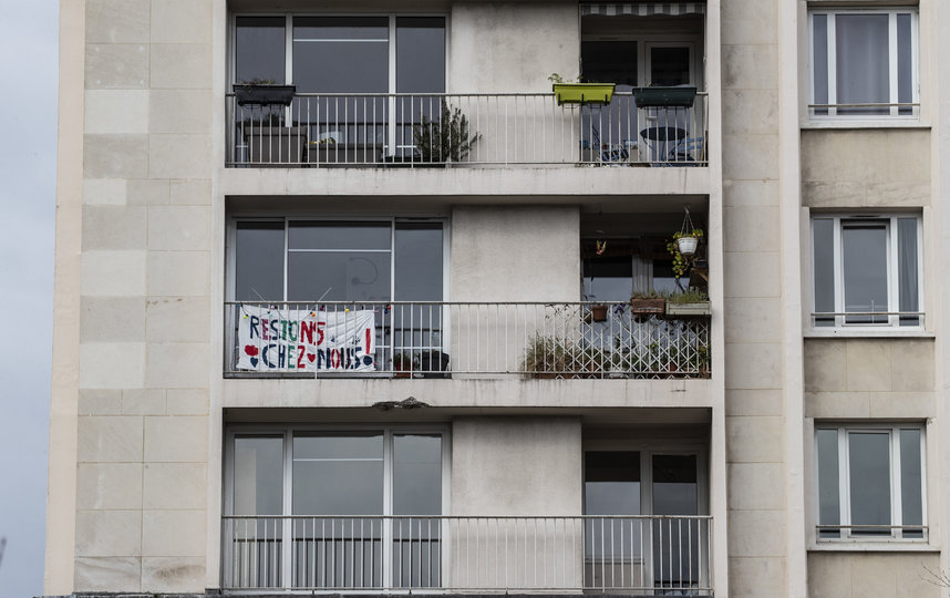 Украшают балконы плакатами. Надпись гласит: "Давайте останемся дома". Париж, Франция. Фото AFP