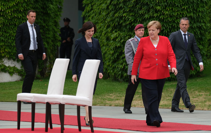 Мир облетели фото с Меркель, которая вновь не встала на исполнение гимнов